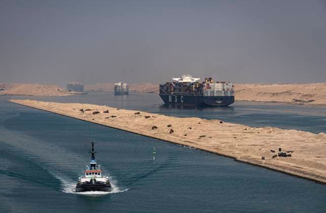 Der Suezkanal: Schnellster Seeweg zwischen Asien und Europa. Ein Lotsenboot und Containerschiffe wie die MSC Deila befahren hier bei Ismailia (Ägypten) vor der Wüstenkulisse von Sinai den Suezkanal. Der 164 km lange Suezkanal gehört zu den weltweit wichtigsten Wasserstraßen. Der Kanal, der das Mittelmeer mit dem Roten Meer verbindet, ist Teil der maritimen Seidenstraße. Rund zwölf Prozent des internationalen Seehandels verlaufen über den Kanal. Suez Ägypten *** The Suez Canal Fastest sea route between Asia and Europe A pilot boat and container ships like the MSC Deila navigate the Suez Canal here near Ismailia Egypt against the desert backdrop of Sinai The 164-km-long Suez Canal is one of the worlds most important waterways The ca