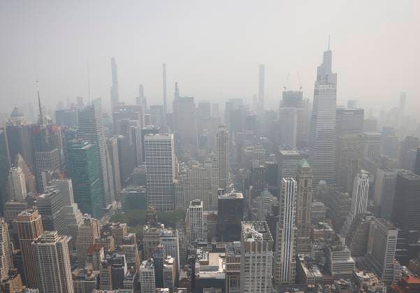 Tourists visit the observation deck of the Empire State Building as haze and smoke due to on going wildfires in Canada shroud the views of One Vanderbilt and the Manhattan skyline on Friday, June 30, 2023 in New York City.  NYP20230630116 JohnxAngelillo