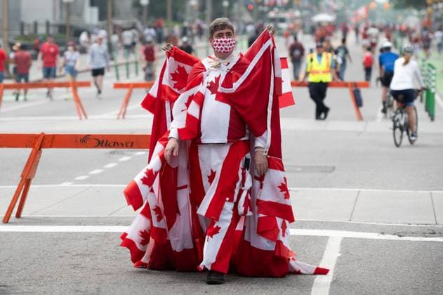 July 1, 2023, Ottawa, ON, Canada: A man covered in Canadian Flags walks down Wellington St., as people take part in Canada Day celebrations in downtown Ottawa, on Saturday, July 1, 2023. Ottawa Canada  - ZUMAc35_ 20230701_zaf_c35_076 Copyright: xSpencerxColbyx