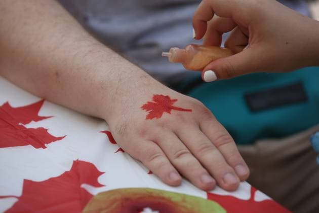 Canadians Celebrate Canada Day In Toronto Woman paints a maple leaf on the hand of a man at a temporary tattoo station as Toronto Canada  Copyright: xCreativexTouchxImagingxLtdx originalFilename: friedman-canadian230701_np9iz.jpg