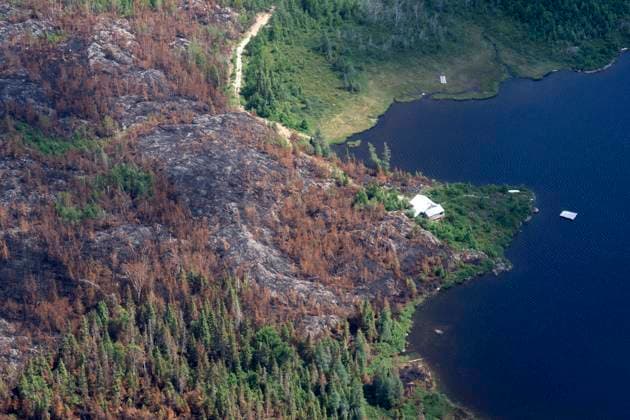 July 5, 2023, Lebel-sur-Quevillon, PQ, Canada: A building stands just a short distance away from where fires burnt through the forest near Lebel-sur-Quevillon, Que., Wednesday, July 5, 2023. Lebel-sur-Quevillon Canada  - ZUMAc35_ 20230705_zaf_c35_068 Copyright: xAdrianxWyldx