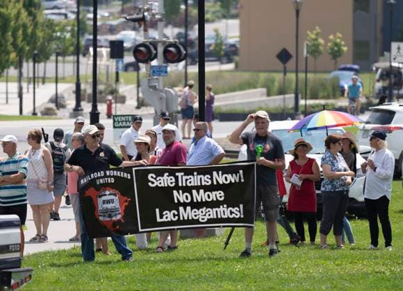 July 6, 2023, LAC MEGANTIC, PQ, CANADA: People hold a sign outside Sainte-Agnes Church following a commemorative mass to pay tribute to the 47 lives lost on the tenth anniversary of the 2013 rail disaster in Lac Megantic, Que. on Thursday, July 6, 2023. LAC MEGANTIC CANADA  - ZUMAc35_ 20230706_zaf_c35_037 Copyright: xChristinnexMuschix