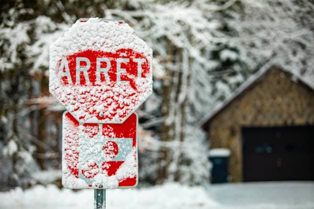 Road warning sign after snow storm A selective focus shot of a French Canadian traffic control sign saying stop, covered with snow and ice after a hazardous snowstorm, copy space to right Copyright: xZoonar.com VALMEDIAx 14989218