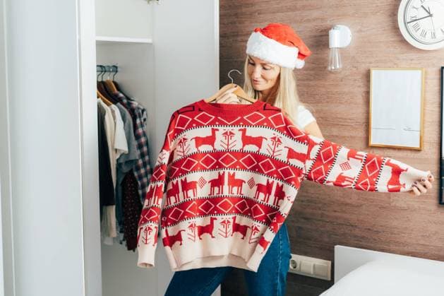 A woman tries on a Christmas sweater to celebrate. Preparing for the New Year holidays. Cozy knitted sweater. A woman tries on a Christmas sweater to celebrate. Preparing for the New Year holidays. Cozy knitted sweater. ,model released, Symbolfoto Copyright: xZoonar.com TITOVAxILONAx 20370057 ,model released, Symbolfoto ,property released