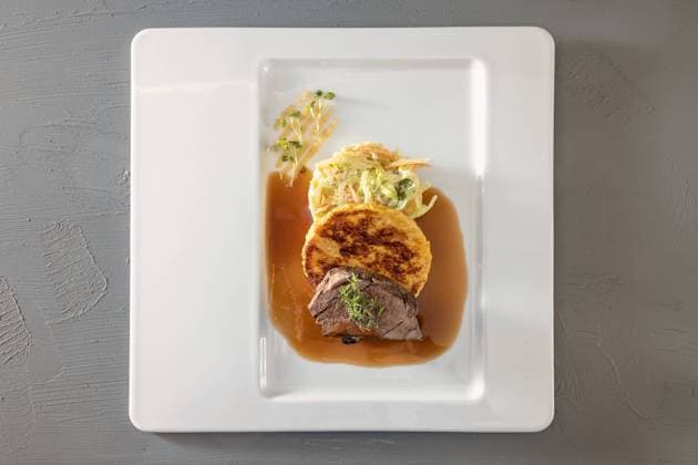 Roast venison meat, fried bread dumpling and ro cabbage vegetable with brown sauce and thyme garnish on a white plate, main course in a menu, high angle view from above, copy space Roast venison meat, fried bread dumpling and ro cabbage vegetable with brown sauce and thyme garnish on a white plate, main course in a menu, high angle view from above, copy space, selected focus Copyright: xZoonar.com MARENxWINTERx 20407682