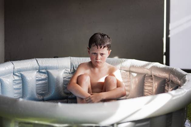 MR_ID14243_13482_EtxahunUnzueta.jpg Dejected cute shirtless child with wet hair sitting in inflatable pool with folded legs and hands on knees while looking at camera in daylight, Model released HodeiUnzueta_ID14243_428975_017 Copyright: xHodeixUnzuetax MR