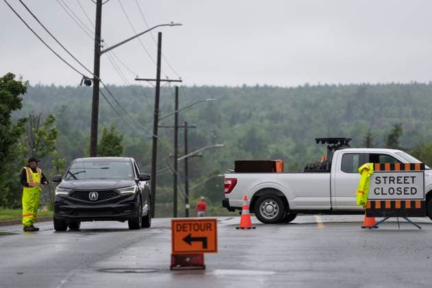 July 22, 2023, Halifax, NS, Canada: A worker diverts traffic at a roadblock following a major rain event that washed out roadways in Halifax on Saturday, July 22, 2023. A long procession of intense thunderstorms have dumped record amounts of rain across a wide swath of Nova Scotia, causing flash flooding, road washouts and power outages. Halifax Canada  - ZUMAc35_ 20230722_zaf_c35_023 Copyright: xDarrenxCalabresex