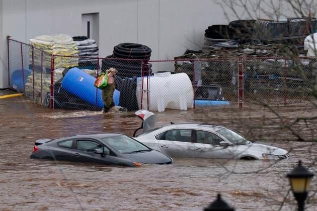 News Bilder des Tages July 22, 2023, Halifax, NS, Canada: A man wearing chest waders walks past cars abandoned in floodwater in a mall parking lot following a major rain event in Halifax on Saturday, July 22, 2023. Halifax Canada  - ZUMAc35_ 20230722_zaf_c35_029 Copyright: xDarrenxCalabresex