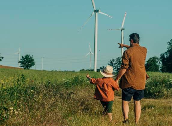 Father and son gesturing towards wind turbines at field model released, Symbolfoto, VSNF01080