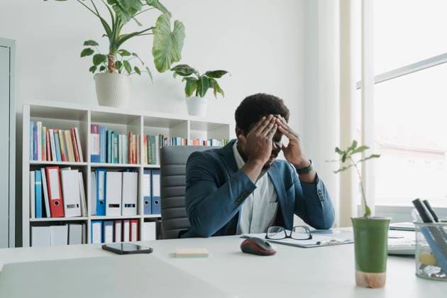 Businessman with head in hand at desk in office model released, Symbolfoto property released, OSF01731