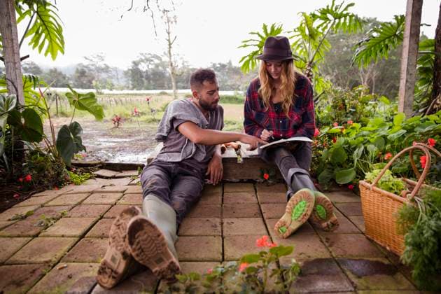 Young couple with diary sitting in garden model released, Symbolfoto property released, IKF00951