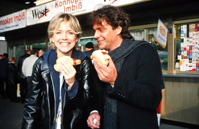 Michael Heck, deutscher Schlagersänger und Komponist isst mit Inka Bause Bruch unterwegs in Berlin eine Ketwurst, Deutschland 1999. Berlin Berlin Deutschland Copyright: xUnitedxArchivesx xAlexanderxStingl STI_8704000114 EDITORIAL USE ONLY