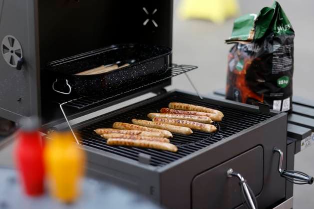 Grillwürste liegen auf einem Kohlegrill. Im Vordergrund Ketchup und Senf. (Themenbild, Symbolbild) Köln, 25.07.2023 NRW Deutschland *** Grilled sausages lie on a coal grill In the foreground ketchup and mustard Theme image, symbol image Cologne, 25 07 2023 NRW Germany Copyright: xChristophxHardtx