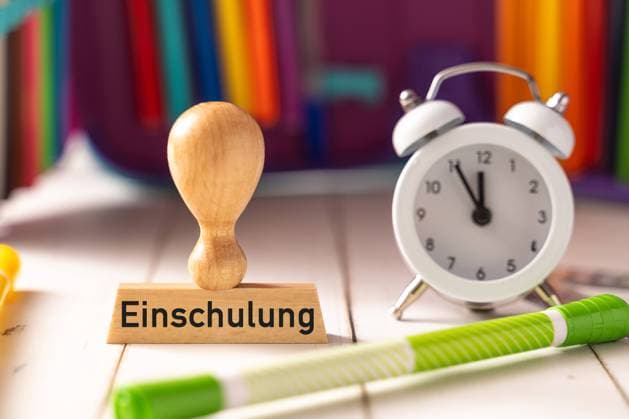 8 August 2023: Symbol image enrollment for children in school. Stamp made of wood with inscription: Enrollment in school next to school pencil case and colorful pens PHOTOMONTAGE *** Symbolbild Einschulung für Kinder in der Schule. Stempel aus Holz mit Aufschrift: Einschulung neben Schulmäppchen und bunten Stiften FOTOMONTAGE