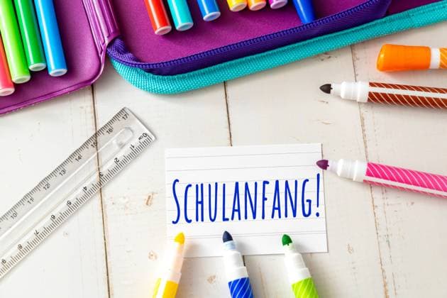 8 August 2023: Note with text: start of school next to colorful pens and a schoolbag. Symbol image enrollment and start of school for pupils PHOTO MONTAGE *** Notiz mit Text: Schulanfang neben bunten Stiften und einem Schulmäppchen. Symbolbild Einschulung und Schulanfang für Schüler FOTOMONTAGE