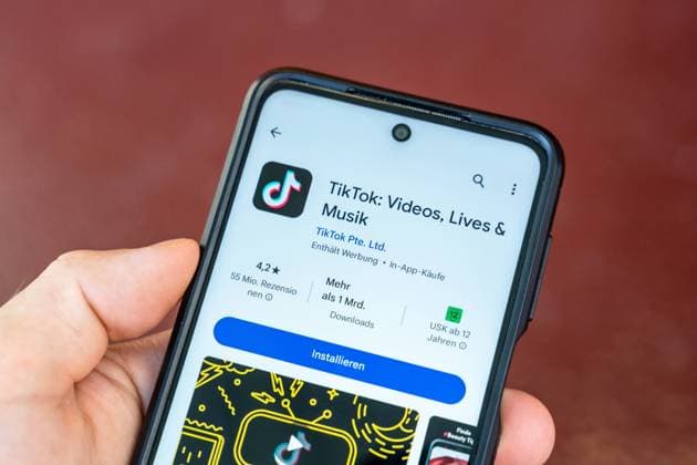 6 August 2023: TikTok app in Google Play Store on a smartphone held by one hand *** TikTok App im Google Play Store auf einem Smartphone das von einer Hand gehalten wird