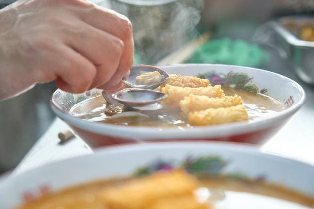 Crop anonymous male chef adding shellfish to appetizing hot soup with soba noodles and deep fried chicken skin in batter while working in restaurant kitchen Model Released PhilippeDegroote_ID14461_434419_013 Copyright: xPhilippexDegrootex