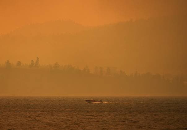 August 18, 2023, KELOWNA, BC, CANADA: A person travels in a boat on Okanagan Lake as smoke from the McDougall Creek wildfire blankets the area, in Kelowna, B.C., Friday, Aug. 18, 2023. KELOWNA CANADA  - ZUMAc35_ 20230818_zaf_c35_051 Copyright: xDarrylxDyckx