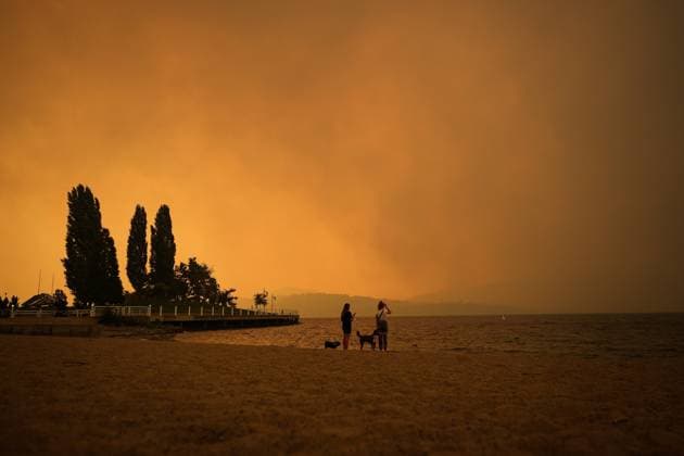 August 18, 2023, KELOWNA, BC, CANADA: Smoke from the McDougall Creek wildfire fills the air and nearly blocks out the sun as people take in the view of Okanagan Lake from Tugboat Beach, in Kelowna, B.C., Friday, Aug. 18, 2023. KELOWNA CANADA  - ZUMAc35_ 20230818_zaf_c35_053 Copyright: xDarrylxDyckx