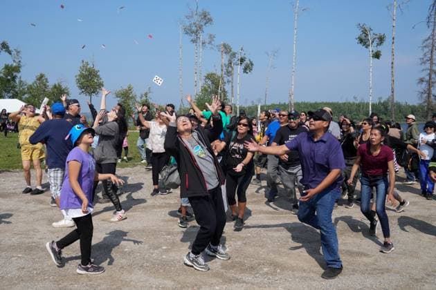 August 18, 2023, NESKANTAGA, ON, CAN: People scramble to catch playing card during the envelope toss game, which offers cash prizes, during the Neskantaga First Nation Summer Festival, in Neskantaga, Ont., Friday, Aug. 18, 2023. NESKANTAGA CAN - ZUMAc35_ 20230818_zaf_c35_089 Copyright: xChrisxYoungx