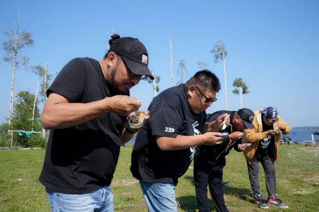 August 18, 2023, NESKANTAGA, ON, CAN: Sol Mamakwa, MPP for Kiiwetinoong (left) joins Neskantaga s Chief Chris Moonias (second left) and other contestants in the annual sardine eating contest, during the Neskantaga First Nation Summer Festival, in Neskantaga, Ont., Friday, Aug. 18, 2023. NESKANTAGA CAN - ZUMAc35_ 20230818_zaf_c35_098 Copyright: xChrisxYoungx