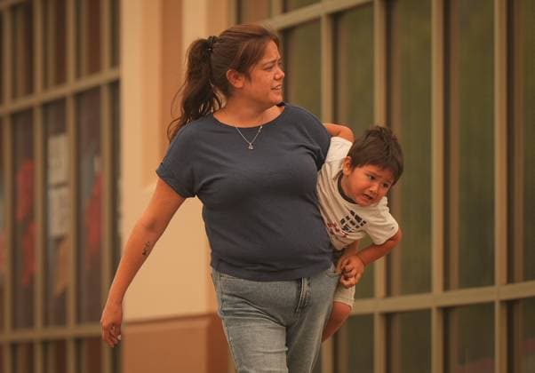 August 19, 2023, KELOWNA, BC, CANADA: A woman carries a young boy outside an evacuation centre for those forced from their homes due to wildfires, in Kelowna, B.C., Saturday, Aug. 19, 2023. KELOWNA CANADA  - ZUMAc35_ 20230819_zaf_c35_021 Copyright: xDarrylxDyckx