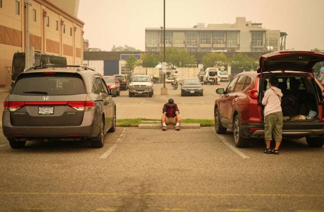 August 19, 2023, KELOWNA, BC, CANADA: A man sits in the parking lot outside an evacuation centre for those forced from their homes due to wildfires, in Kelowna, B.C., Saturday, Aug. 19, 2023. KELOWNA CANADA  - ZUMAc35_ 20230819_zaf_c35_022 Copyright: xDarrylxDyckx