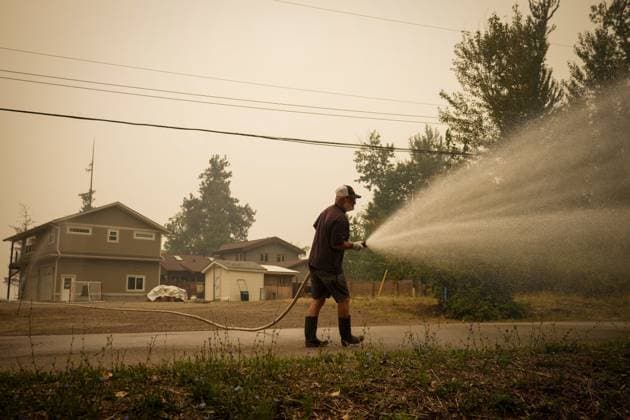 August 20, 2023, SCOTCH CREEK, BC, CANADA: Trevor Manzuik, who was evacuated from his home due to the Lower East Adams Lake wildfire, sprays down the brush on the road in front of his property after returning home by boat, in Scotch Creek, B.C., on Sunday, August 20, 2023. SCOTCH CREEK CANADA - ZUMAc35_ 20230820_zaf_c35_109 Copyright: xDarrylxDyckx