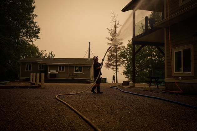 August 20, 2023, SCOTCH CREEK, BC, CANADA: Trevor Manzuik, who was evacuated from his home due to the Lower East Adams Lake wildfire, sprays down his property after returning home by boat, in Scotch Creek, B.C., on Sunday, August 20, 2023. SCOTCH CREEK CANADA - ZUMAc35_ 20230820_zaf_c35_111 Copyright: xDarrylxDyckx