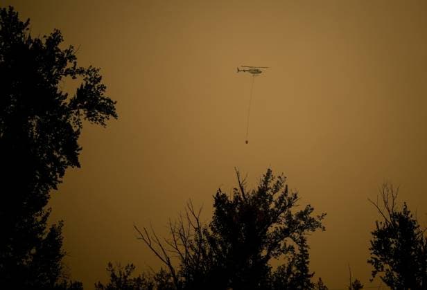 August 20, 2023, SCOTCH CREEK, BC, CANADA: A helicopter carrying a water bucket is used to drop water on the Lower East Adams Lake wildfire burning in Scotch Creek, B.C., on Sunday, August 20, 2023. SCOTCH CREEK CANADA  - ZUMAc35_ 20230820_zaf_c35_116 Copyright: xDarrylxDyckx
