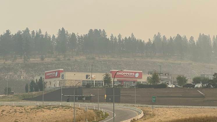 (230821) -- KELOWNA, Aug. 21, 2023 -- Smoke from wildfires hangs over a street in Kelowna, British Columbia, Canada, on Aug. 20, 2023. Canada s British Columbia government said Saturday it will implement a restriction on non-essential travel to areas affected by wildfires amid its state of emergency. The government has declared a provincial state of emergency as thousands evacuated from their homes. (Photo by Wan Bin Xinhua) CANADA-BRITISH COLUMBIA-KELOWNA-WILDFIRE-SMOKE LinxWei 