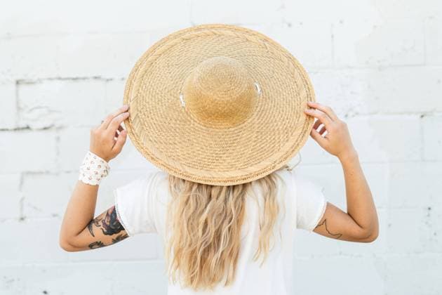 A woman wearing a large wicker hat Iowa City, Iowa, United States CR_VGMI230815-1231693-01 ,model released, Symbolfoto