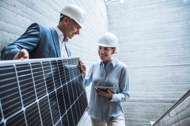 Happy engineers discussing over solar panel model released, Symbolfoto property released, UUF29812