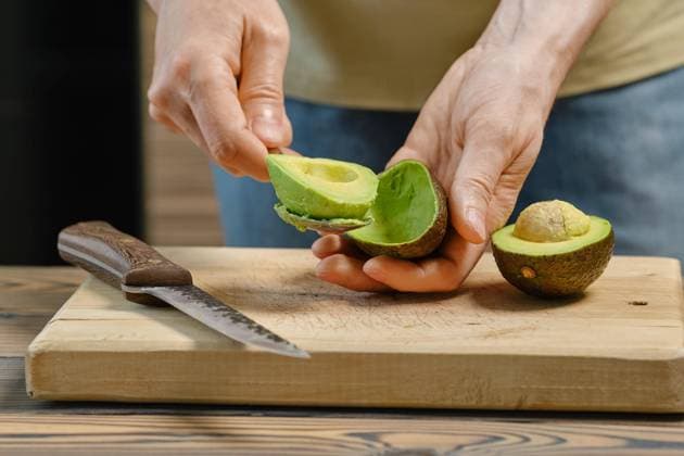  Nahaufnahme einer männlichen Hand, die mit einem Löffel eine Avocado aus der Schale löst *** Close-up a male Hand, the with a Spoons a Avocado from the Bowl solves Copyright: imageBROKER/AlekseixIsachenko ibxaii09540053.jpg ,model released, Symbolfoto ,property released