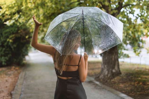 cheerful woman with umbrella checks the rain Varna, Varna, Bulgaria R_PUZV230731-1224543-01 ,model released, Symbolfoto