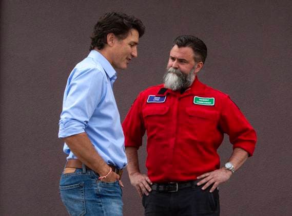 August 25, 2023, West Kelowna, BC, Canada: Prime Minister Justin Trudeau, left, speaks with Brad Litke of the BC Wildfire Service outside a fire hall in West Kelowna, B.C. on Friday, Aug. 25, 2023. West Kelowna Canada  - ZUMAc35_ 20230825_zaf_c35_117 Copyright: xMarissaxTielx