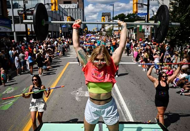 August 27, 2023, Ottawa, ON, CAN: A person marching with a fitness and addictions recovery program lifts weights from atop a float during the Capital Pride Parade in Ottawa, on Sunday, Aug. 27, 2023. Ottawa CAN  - ZUMAc35_ 20230827_zaf_c35_032 Copyright: xJustinxTangx