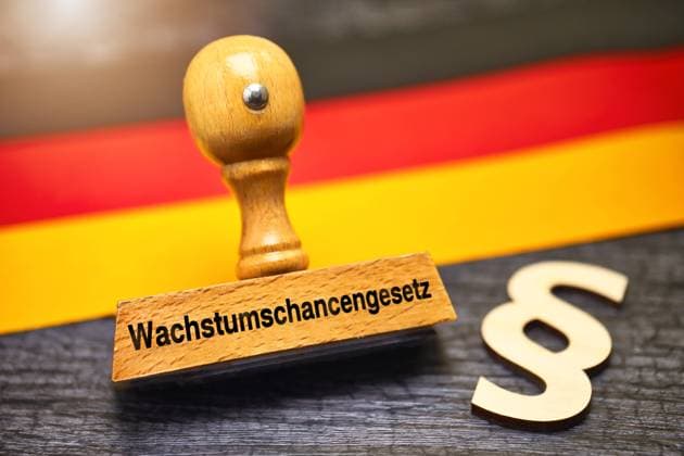 FOTOMONTAGE, Stempel mit Aufschrift Wachstumschancengesetz und Paragrafenzeichen vor Deutschlandfahne *** PHOTOMONTAGE, stamp with inscription Growth Opportunities Act and paragraph sign in front of Germany flag ** NUR FUER REDAKTIONELLE ZWECKE ** EDITORIAL USE ONLY **