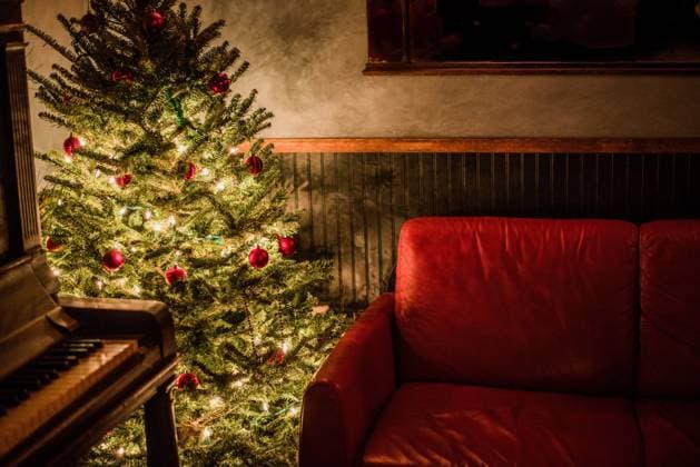 Cozy living room corner with Christmas tree and piano. New York, New York, United States R_NHDH230808-1231613-01