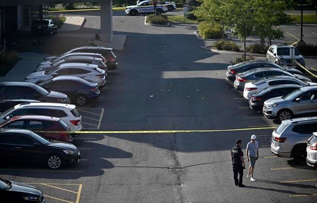 September 3, 2023, Ottawa, ON, CAN: Evidence markers are seen in a parking lot as an Ottawa Police officer speaks with a member of the public after a Saturday night shooting at the Infinity Convention Centre left two dead, in Ottawa, on Sunday, Sept. 3, 2023. Ottawa CAN  - ZUMAc35_ 20230903_zaf_c35_003 Copyright: xJustinxTangx