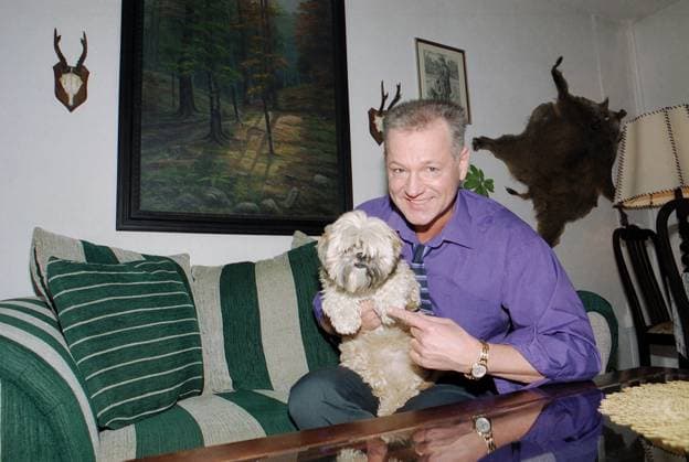 Gerd Christian, deutscher Schlagersänger, mit Hund auf dem Sofa im Wohnzimmer in Berlin, Deutschland 2003. Berlin Berlin Deutschland Copyright: xUnitedxArchivesx xAlexanderxStingl STI_8700000190 EDITORIAL USE ONLY