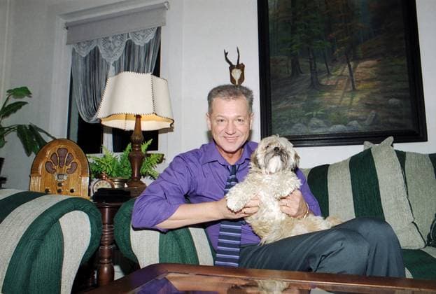 Gerd Christian, deutscher Schlagersänger, mit Hund auf dem Sofa im Wohnzimmer in Berlin, Deutschland 2003. Berlin Berlin Deutschland Copyright: xUnitedxArchivesx xAlexanderxStingl STI_8700000199 EDITORIAL USE ONLY