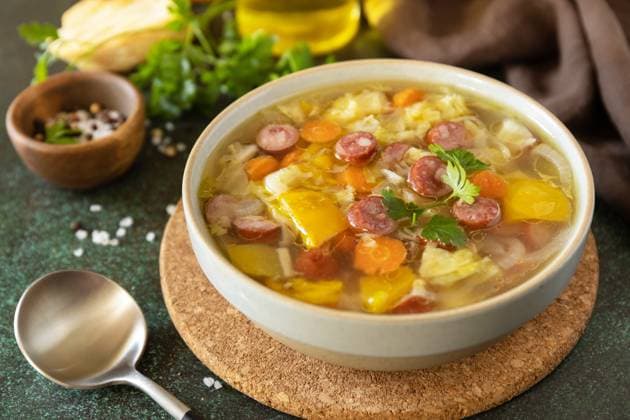 Traditional Zelnacka cabbage soup with sausages and vegetables in a bowl on a stone tabletop. Czech cuisine. Traditional Zelnacka cabbage soup with sausages and vegetables in a bowl on a stone tabletop. Czech cuisine. Copyright: xZoonar.com ELENAxHRAMOVAx 20117228