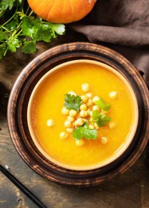 Comfort food, fall and winter healthy slow food concept. Vegetarian pumpkin and chickpea cream soup on a rustic wooden table. View from above. Comfort food, fall and winter healthy slow food concept. Vegetarian pumpkin and chickpea cream soup on a rustic wooden table. View from above. Copyright: xZoonar.com ELENAxHRAMOVAx 20121416