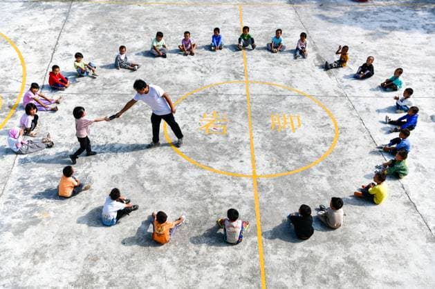 (230910) -- GUIDING, Sept. 10, 2023 -- Lu Chengwen (C) and his students play the game drop-the-handkerchief during a PE class at Yanjiao teaching point in Yanshan Township of Guiding County, southwest China s Guizhou Province, Sept. 6, 2023. Yanjiao teaching point is a micro primary school located at a flat area among mountains in southwest China s Guizhou. Lu Chengwen is the only teacher here with 28 preschool and 6 grade one students. In 2012, Lu, who had just graduated from the university, chose to teach at the remote Yanjiao teaching point. Preschool students, grown up from the mountainous village of the Miao ethnic group, could hardly speak Mandarin Chinese. In order to help his students learn Chinese characters and Mandarin Chi 