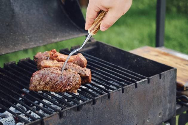  Unbekannter Mann beim Grillen eines Steaks im Freien. Er wendet das Fleisch mit einer Gabel *** Unknown Man at Barbecue one Steaks at Free he turns the Meat with a Fork Copyright: imageBROKER/AlekseixIsachenko ibxaii09635373.jpg ,model released, Symbolfoto ,property released