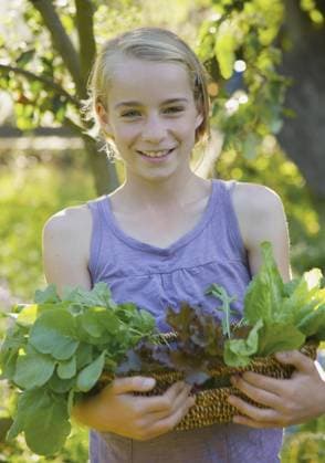 Smiling young girl standing in a garden holding a basket of leafy vegetables United Kingdom  Copyright: JuttaxKlee fStopImages2044150 ,model released, Symbolfoto