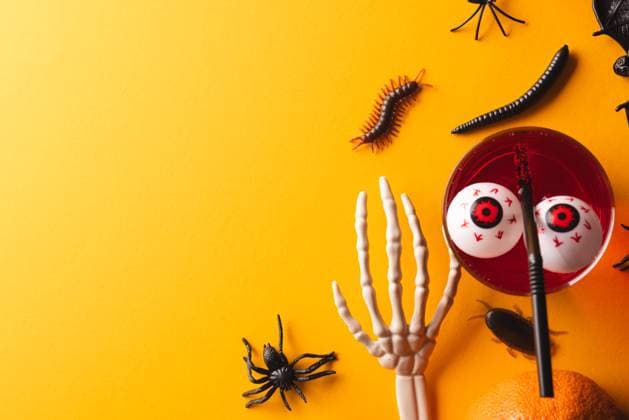Halloween decorations and food with copy space on yellow background. Fall, autumn, halloween, tradition and celebration concept.