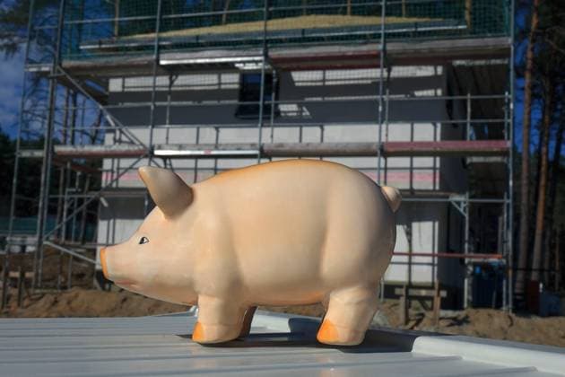Sparschwein und eingerüstetes Einfamilienhaus Sparschwein und eingerüstetes Einfamilienhaus, 21.09.2023, Borkwalde, Brandenburg, Ein Sparschwein steht vor einem eingerüsteten Einfamilienhaus. *** Piggy bank and scaffolded family house Piggy bank and scaffolded family house, 21 09 2023, Borkwalde, Brandenburg, A piggy bank stands in front of a scaffolded family house