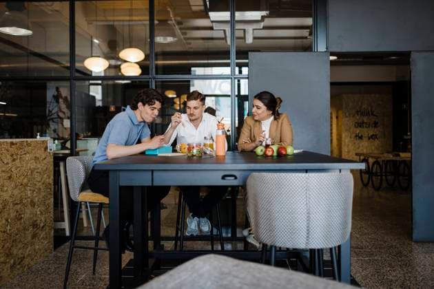 Colleagues having food sitting at table in office model released, Symbolfoto property released, DCRF01777